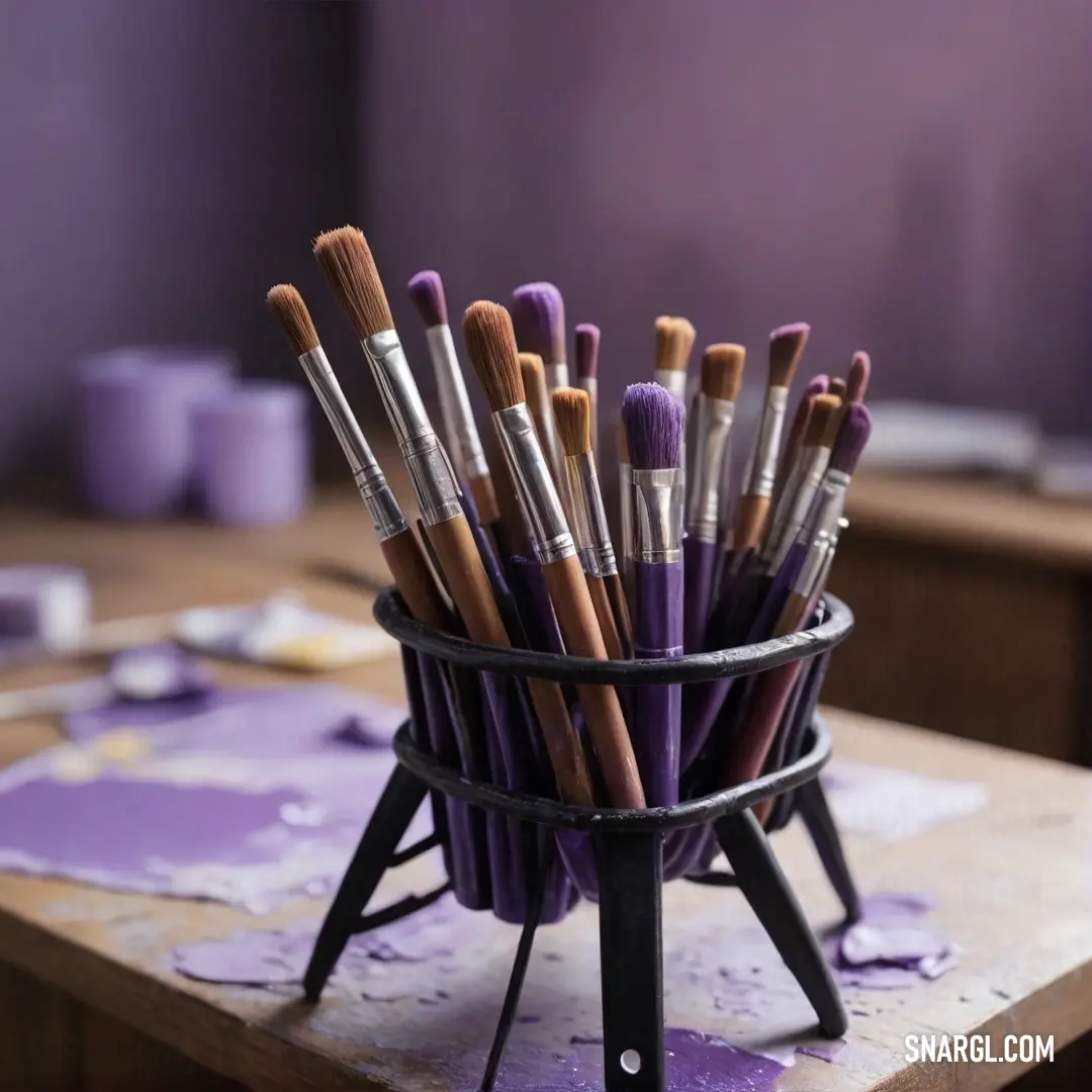 A charming basket filled with an assortment of brushes sits elegantly on a wooden table, complemented by the rich hues of purple walls. This inviting scene reflects an artist's haven, brimming with creativity and the promise of vibrant artwork waiting to 