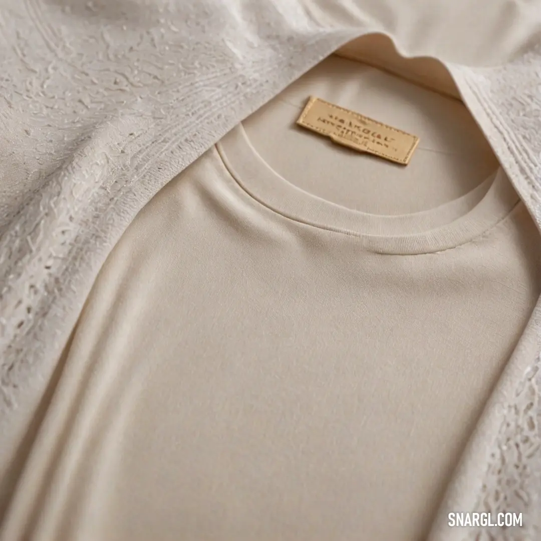 A delicate old rose-colored shirt resting on a soft bed sheet, featuring a name tag prominently displayed on its collar, creating a harmonious blend of elegance and simplicity. The interplay of colors lends a tranquil ambiance to this inviting scene.