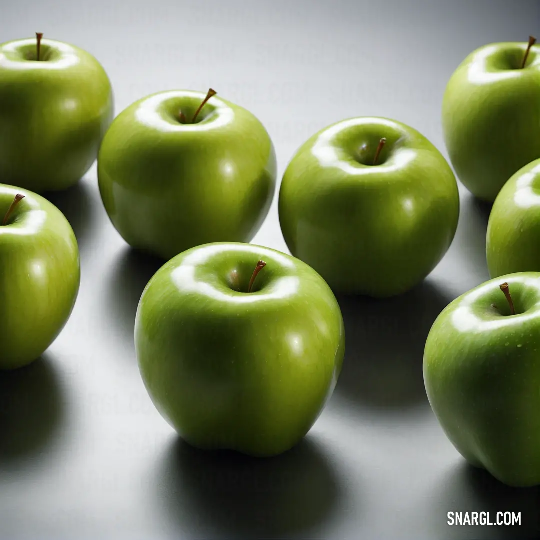 Group of green apples on top of a table next to each other on a table top with a black surface