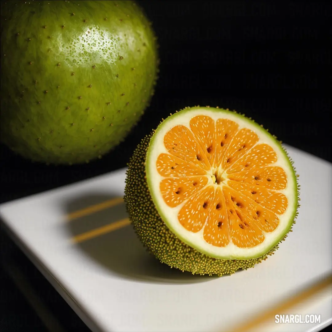 Cut up orange on top of a white plate next to a green apple on a black background