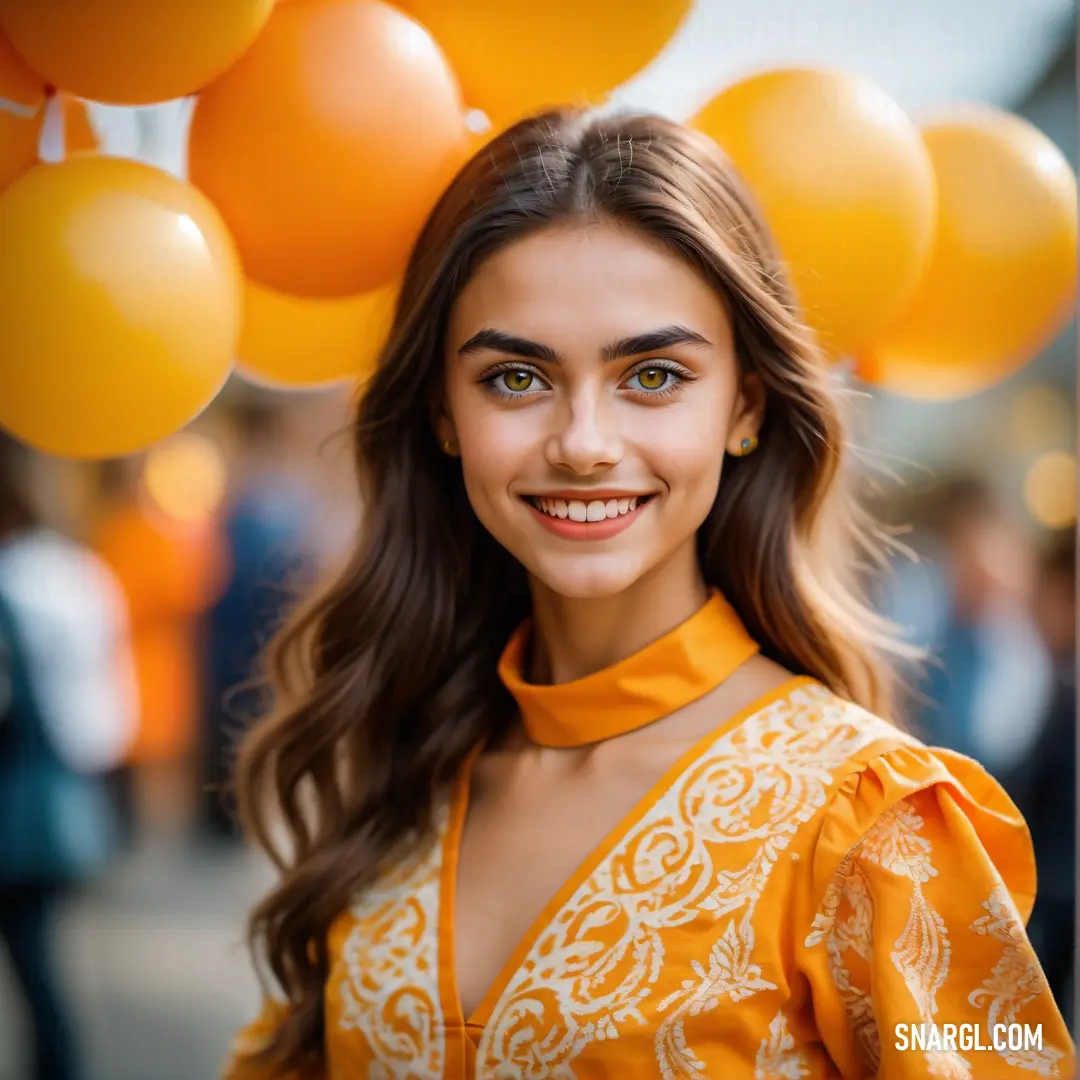 Woman with long hair and a yellow blouse smiles at the camera with balloons in the background. Example of RGB 255,159,0 color.