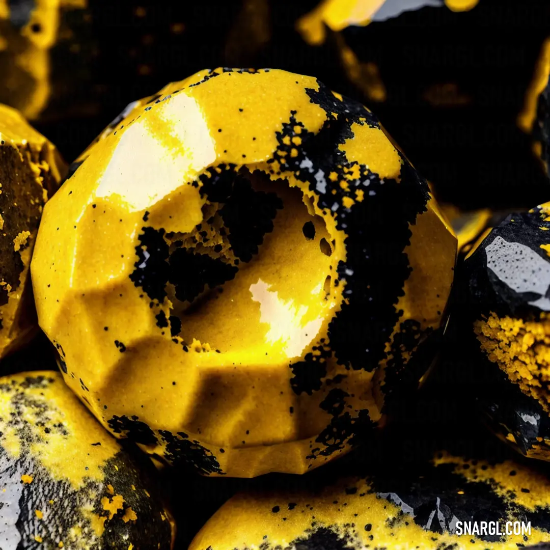 Pile of yellow and black rocks with black dots on them and a black and white donut on top