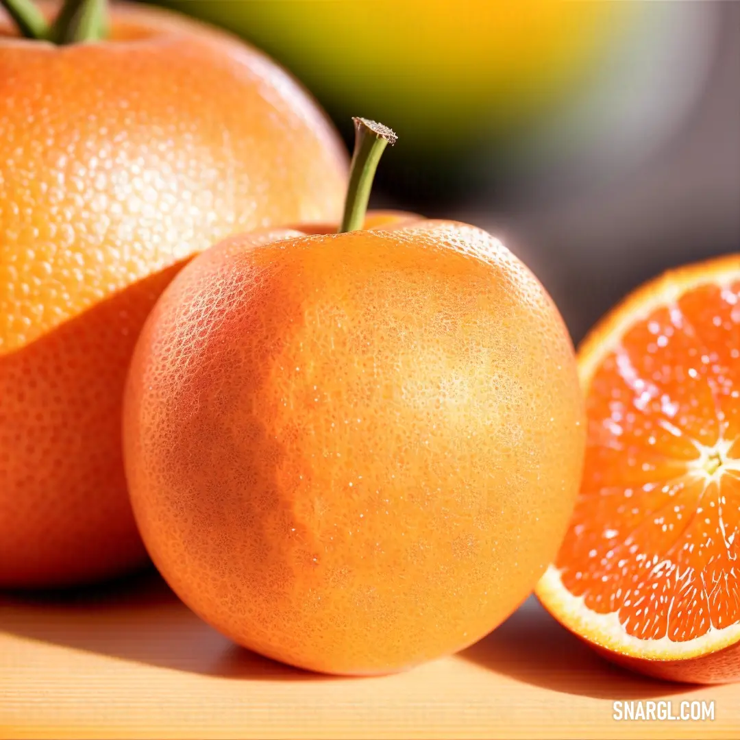Close up of two oranges and one half of an orange on a table with a blurry background