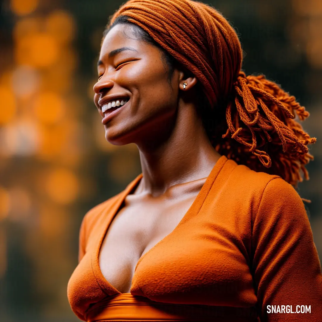 Woman with a bright orange top smiling and looking up at something in the distance with her eyes closed