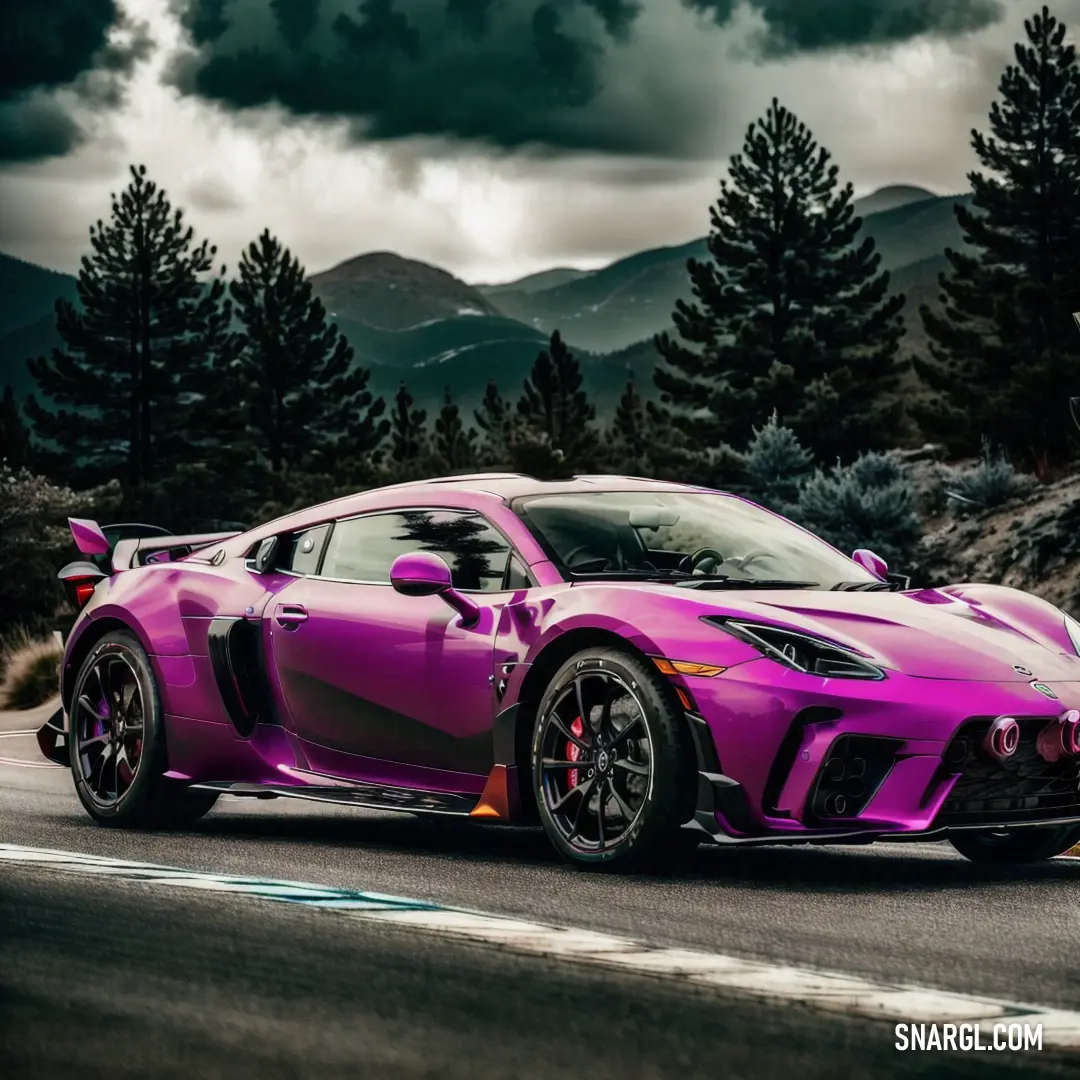 Pink sports car driving down a road with mountains in the background and clouds in the sky above it