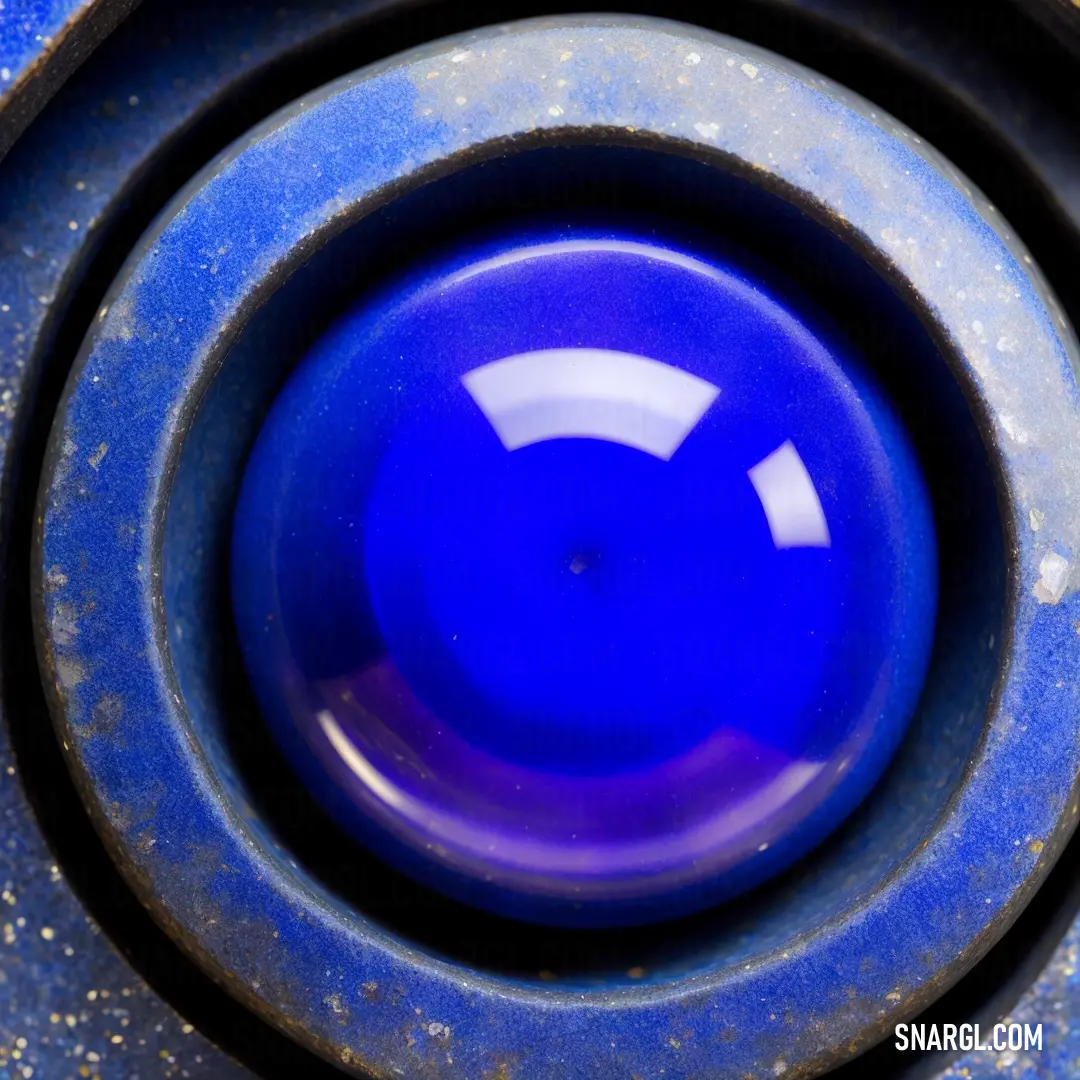Blue object with a white circle in the center of it's center hole. Color CMYK 83,74,0,11.
