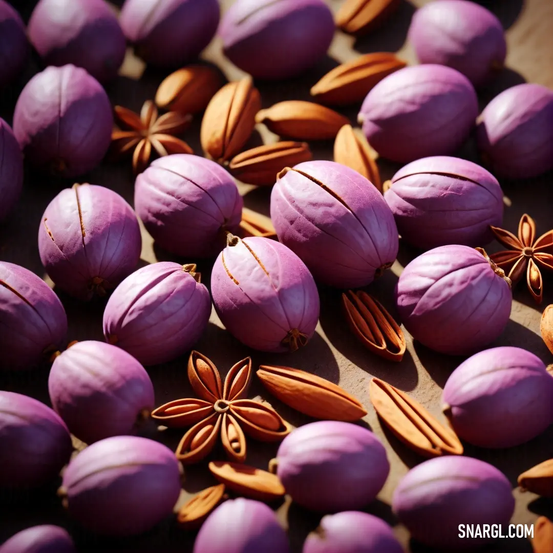 Bunch of purple and orange food on a table with nuts and seeds on it and a star anise. Example of Palatinate purple color.