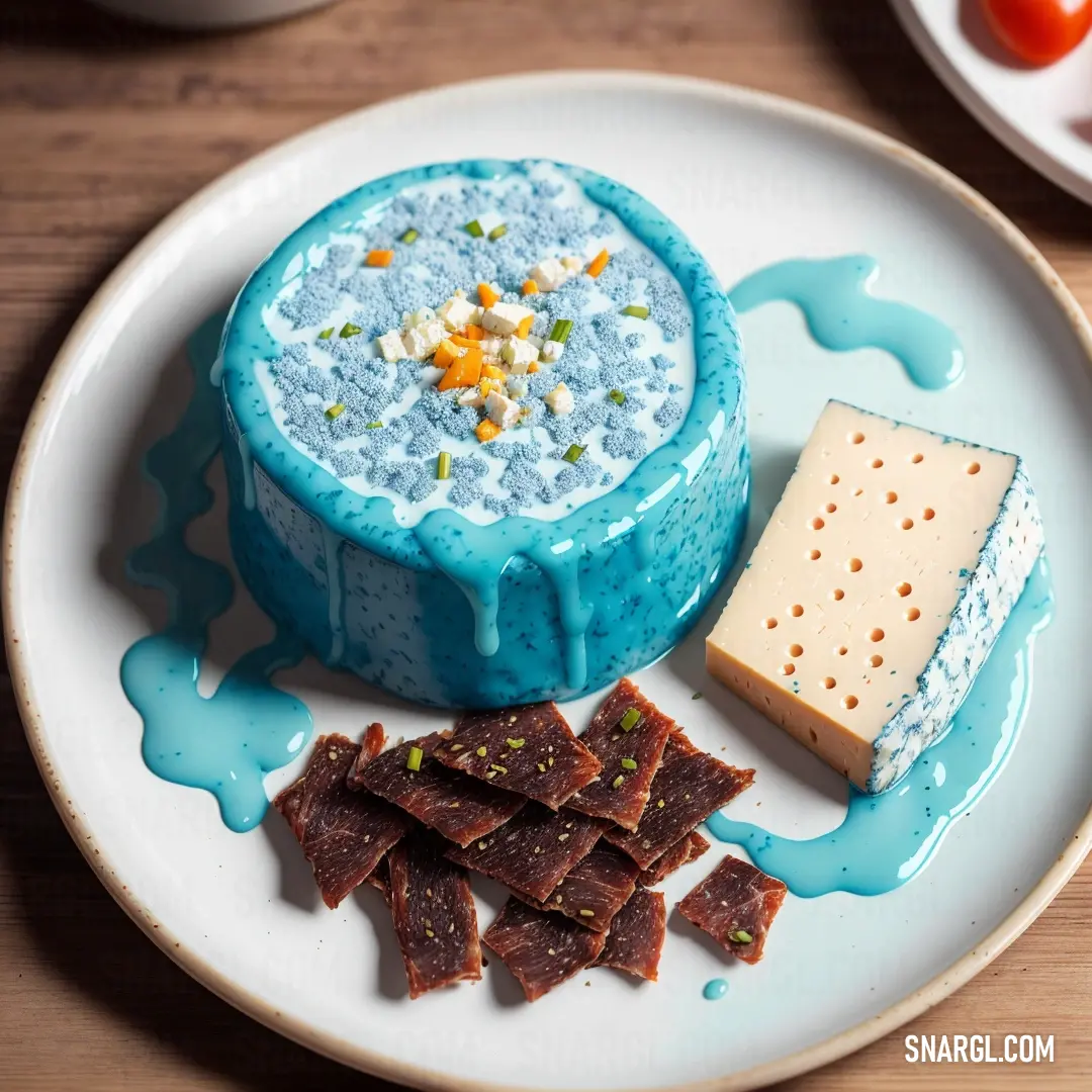 Plate with a blue dessert and some crackers on it and a bowl of cheese