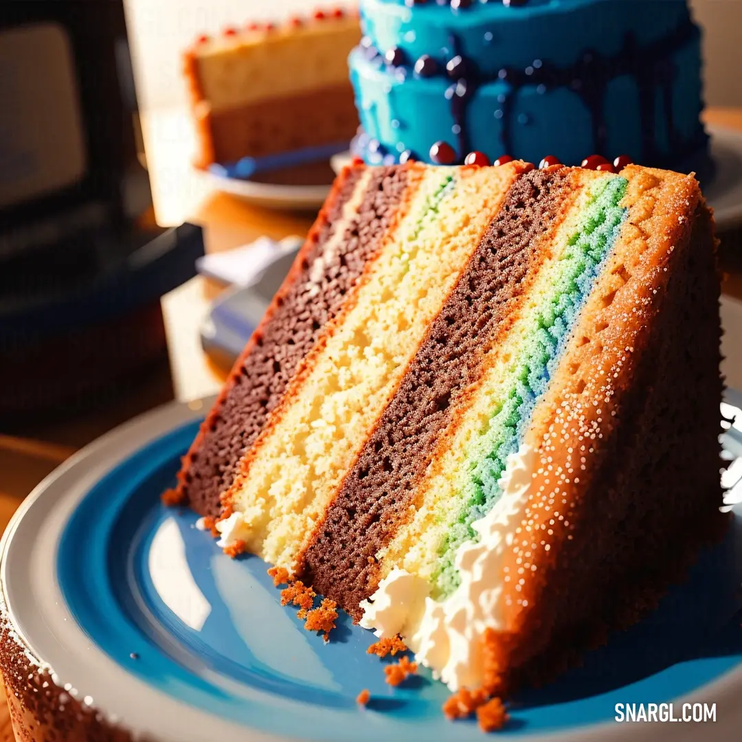 Slice of rainbow cake on a plate with a knife and fork next to it on a table with a microwave