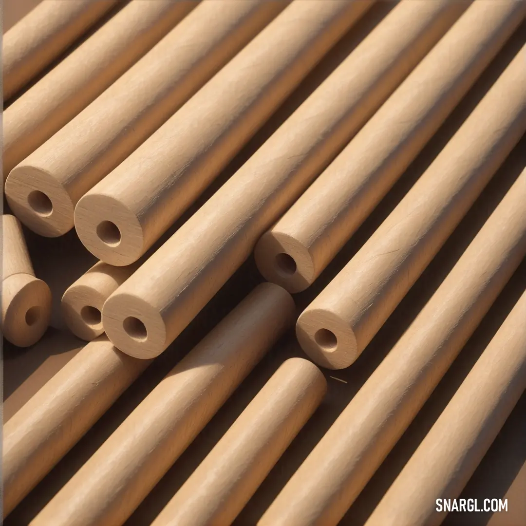 Pale gold color example: Bunch of wooden tubes are lined up together on a table top with a blue frame in the middle