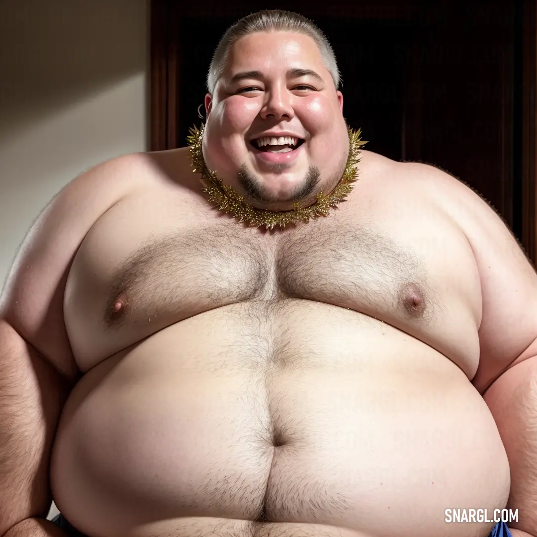 Fat man with a necklace on his neck and a big belly is smiling at the camera while in a chair