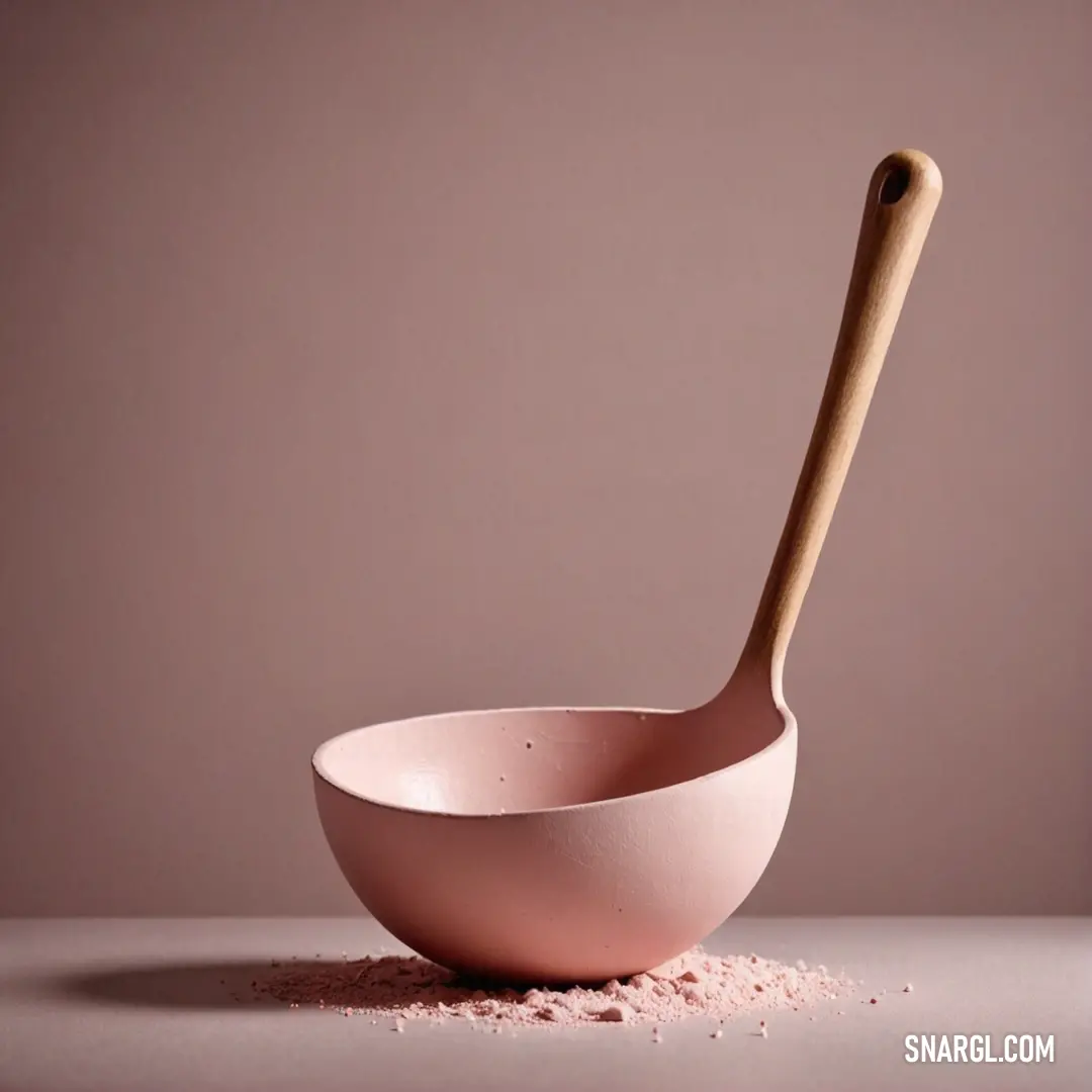 Wooden spoon with a pink bowl on a table. Color #FADADD.