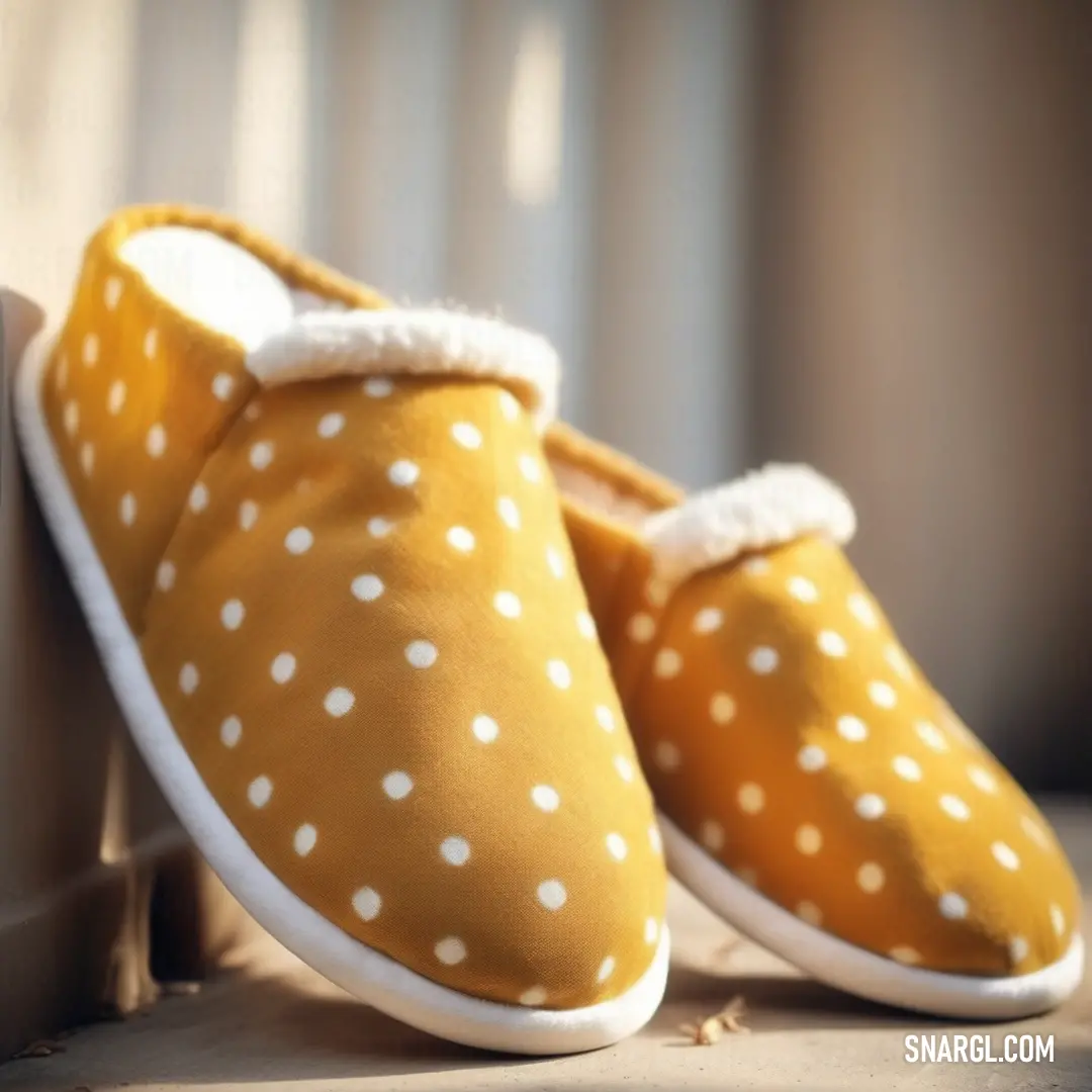 A delightful pair of yellow slippers adorned with playful white polka dots rests on a wooden floor, radiating cheerfulness and comfort within a cozy space.