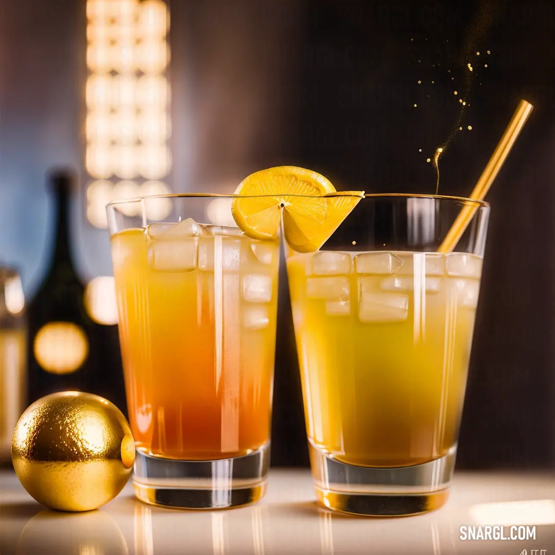 PANTONE 122 color. Two glasses of orange juice with a lemon slice on the rim and a bottle of champagne in the background