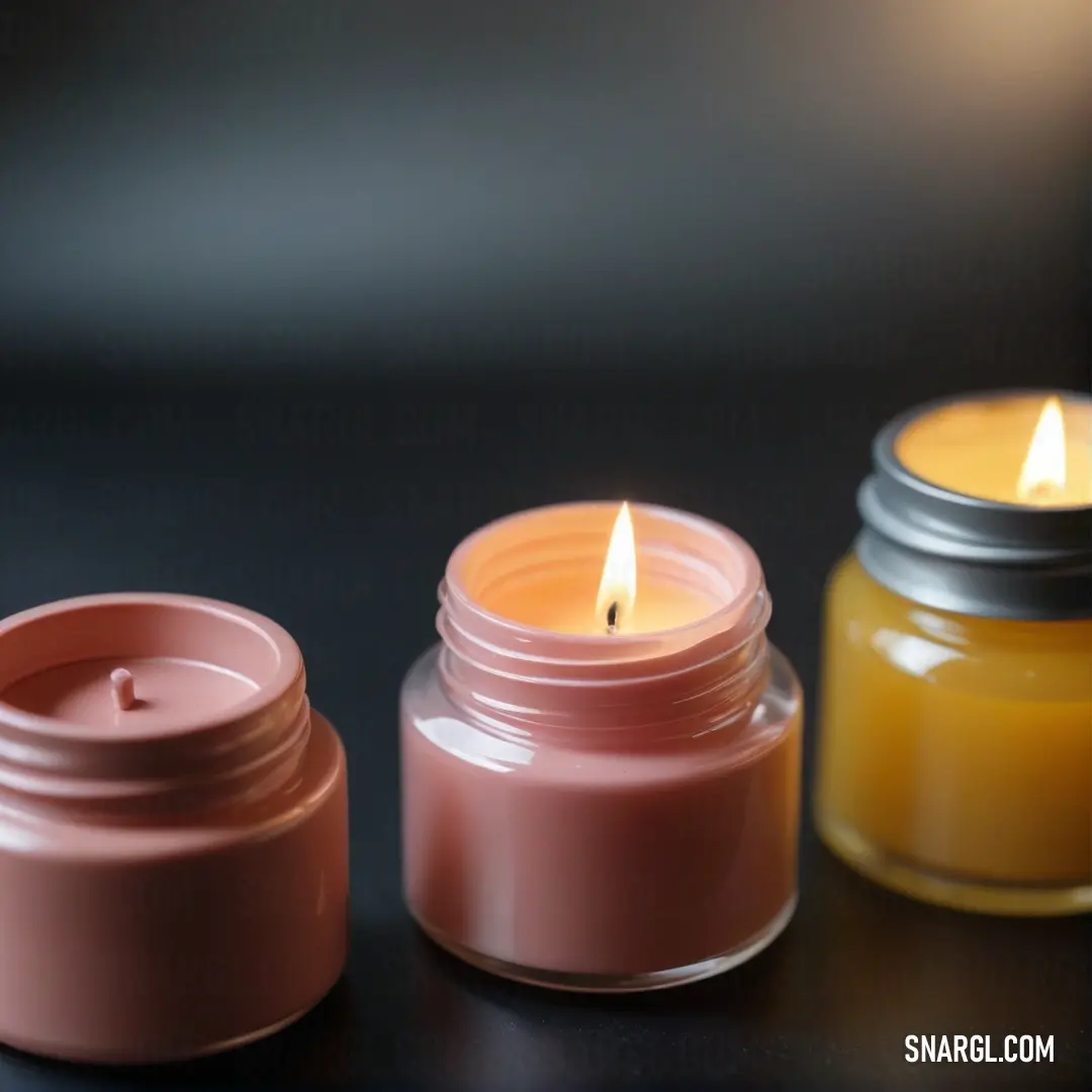 A charming display of jars filled with flickering candles surrounds by a sleek black surface. The soft glow against the background creates a cozy atmosphere, beautifully showcasing the inviting tone of PANTONE 1265.