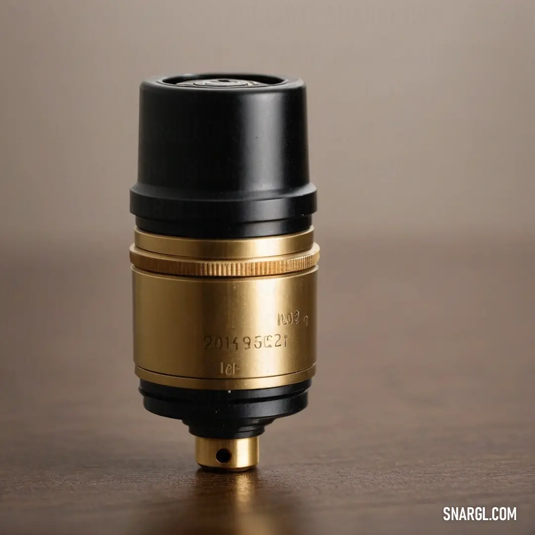 An exquisite gold and black camera lens rests thoughtfully on a rustic wooden table, the rich brown background enhancing its allure. The intricacies of the lens shine through, signifying the artistry and precision involved in capturing timeless moments.