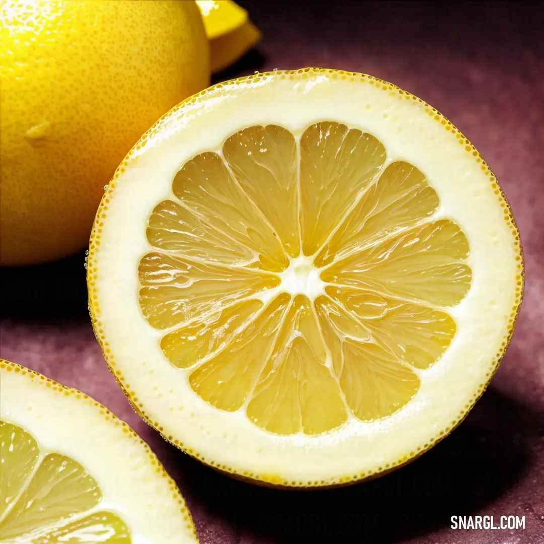 Lemon cut in half next to a lemon slice on a table top with a purple background