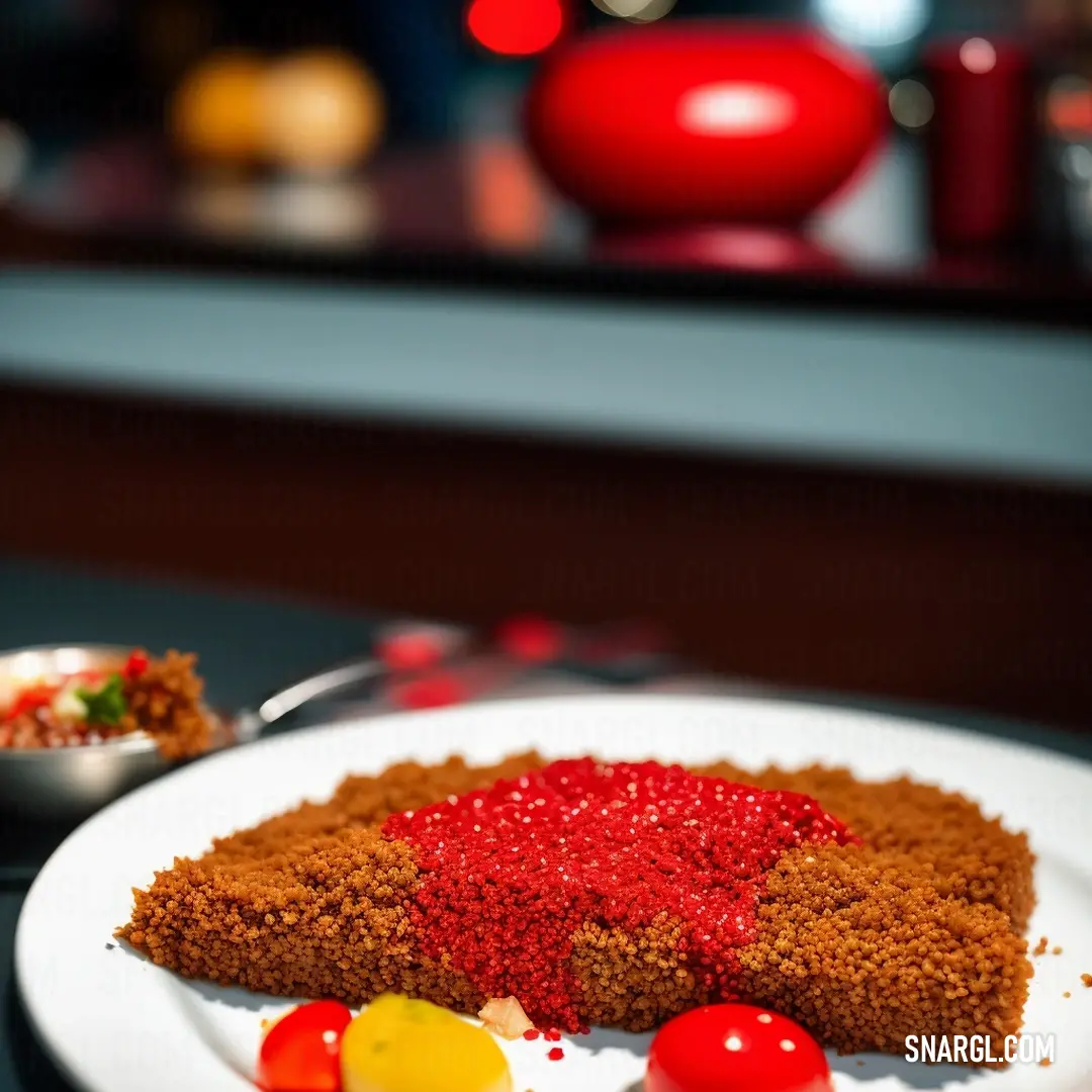 Piece of cake with red icing on a plate with a bowl of candy on the side of it. Example of CMYK 10,72,100,46 color.