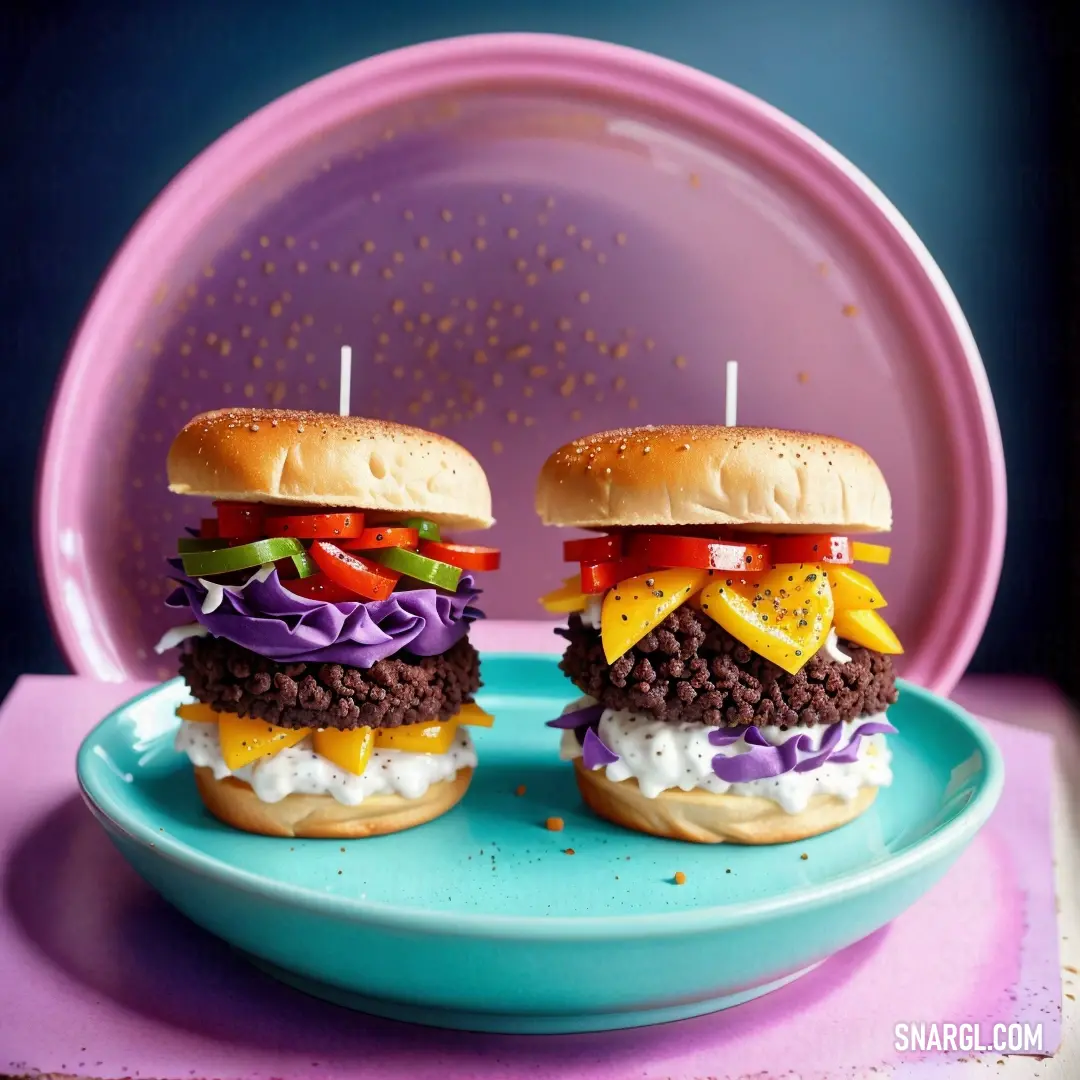 Two hamburgers with a candle on a plate with a purple plate in the background and a pink plate