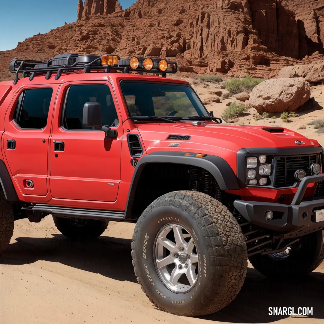 Red truck with a light on top of it in the desert with rocks in the background