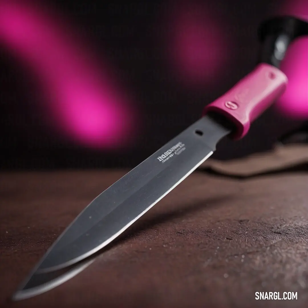 A vibrant knife featuring a playful pink handle sits elegantly on a table next to stylish glasses, all arranged on a textured tablecloth, highlighting the delightful contrast of colors and everyday beauty.