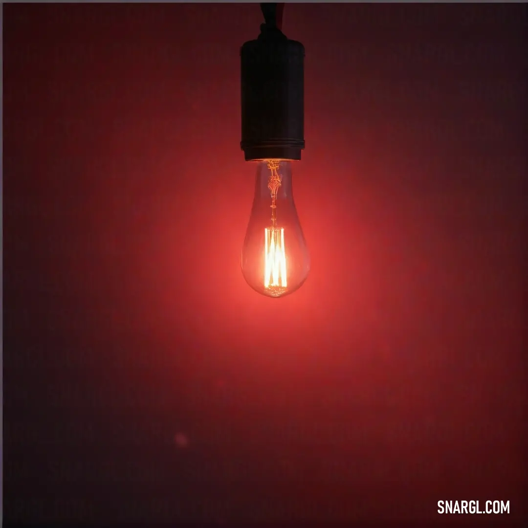 A glowing light bulb stands out brilliantly against a rich red background, symbolizing inspiration and creativity, casting a warm luminosity that captivates the viewer. Color representation is #CC3057.