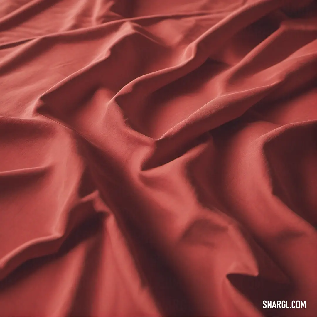 A soft red bedspread with a delicately ruffled edge covers a cozy bed, a fluffy pillow resting on top. The warm red tone invites relaxation, adding an inviting, peaceful ambiance to the room.