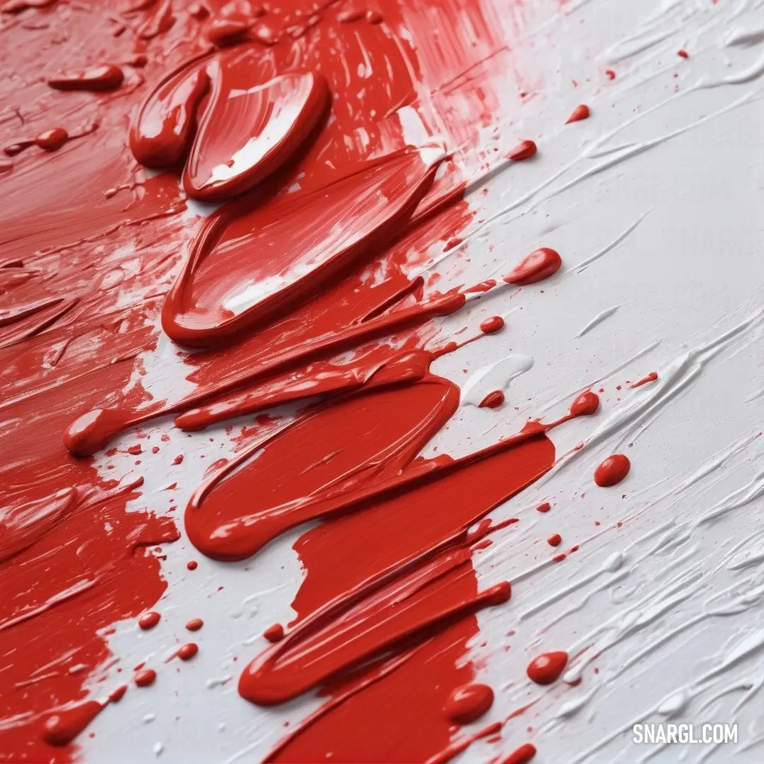 Red paint is artistically poured onto a pristine white surface, creating a vivid contrast with splashes of vibrant red droplets, exemplifying the dynamism of color #CC3057 in action.