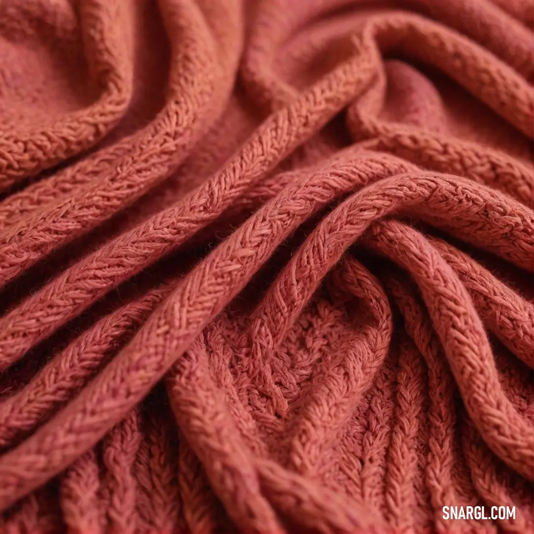 A close-up view of a soft pink knitted blanket engulfed by a radiant red backdrop, showcasing a beautiful interplay of colors and textures that evoke feelings of warmth, comfort, and cozy nestling.