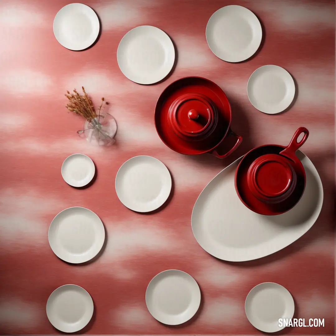 A beautifully set table adorned with elegant plates and cups, complete with a charming vase containing a vibrant flower, resting on a bright red tablecloth dotted with playful white spots, creating an inviting dining atmosphere.