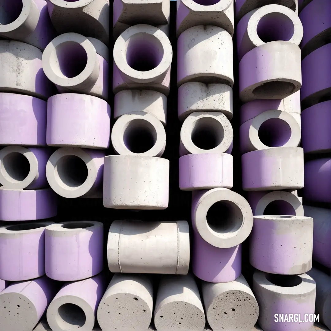 A pile of purple and white concrete pipes stacked on the ground, showing off the striking PANTONE 2043 color. The pipes create an intriguing pattern as they rest in a haphazard yet organized arrangement.