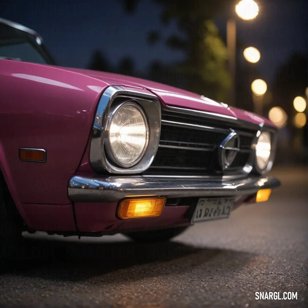 A charming pink car is parked gracefully on the side of a lively street at night. Its headlights illuminate the surroundings, casting a warm glow and enhancing the enchanting atmosphere of the evening.