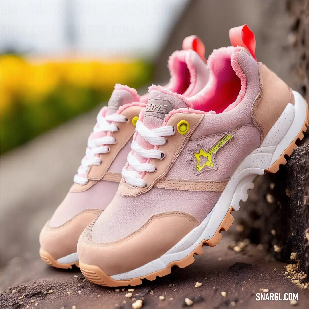 A playful and vibrant pair of pink sneakers with lively yellow accents, delicately placed against a textured rock wall, adorned with a backdrop of colorful flowers, creating an energetic and youthful atmosphere.