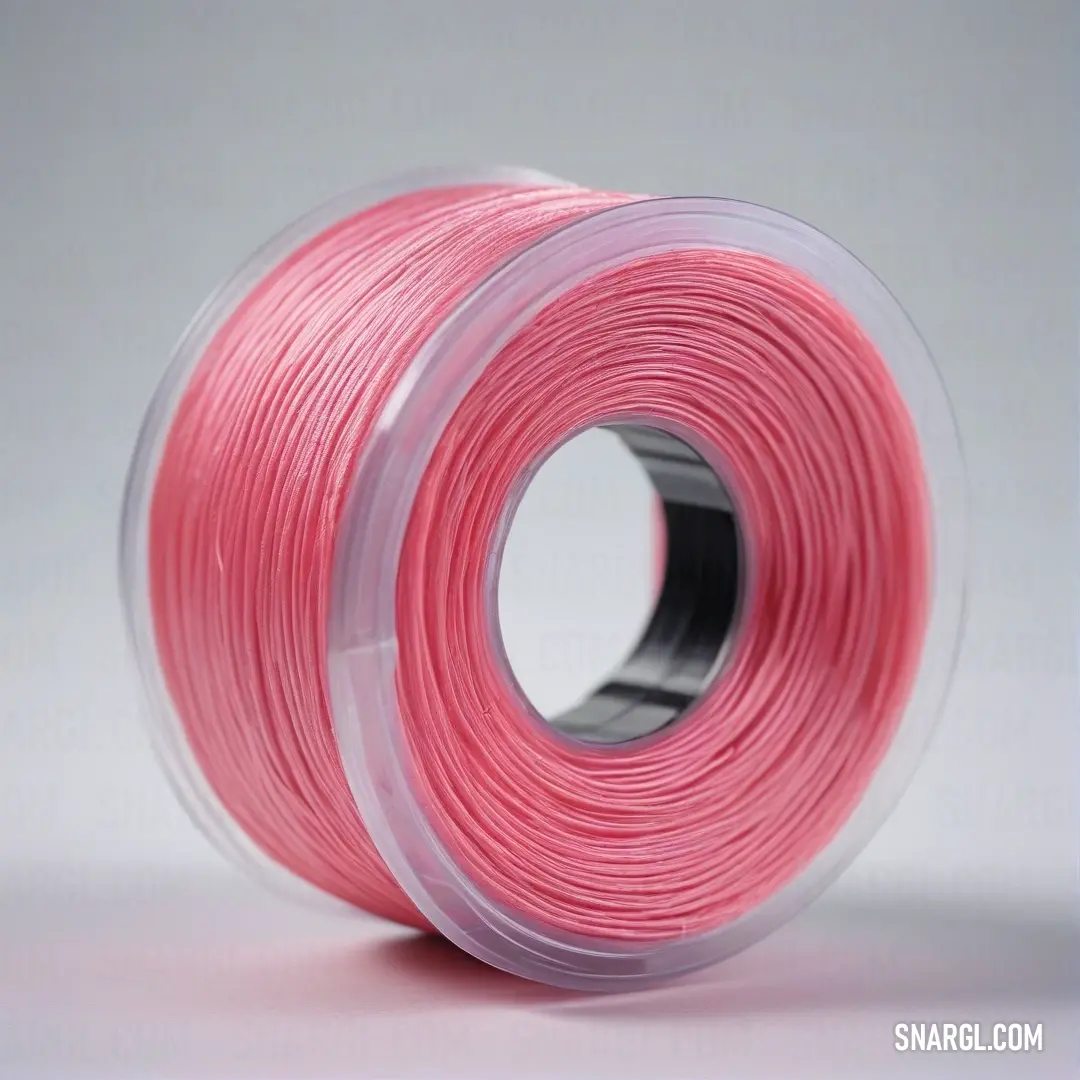 A vivid spool of pink thread rests on a bright white background, epitomizing elegance and creativity, ready to inspire crafting and artistic endeavors.