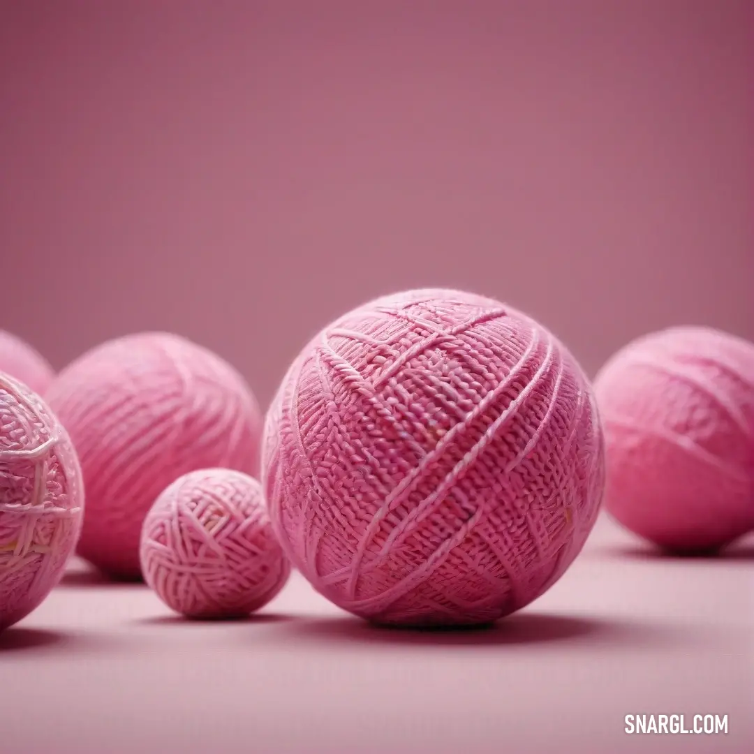 A group of colorful yarn balls is arranged beautifully on a pink background, each one contributing to the overall tone of PANTONE 2060. The subtle interplay of hues creates a visual feast.