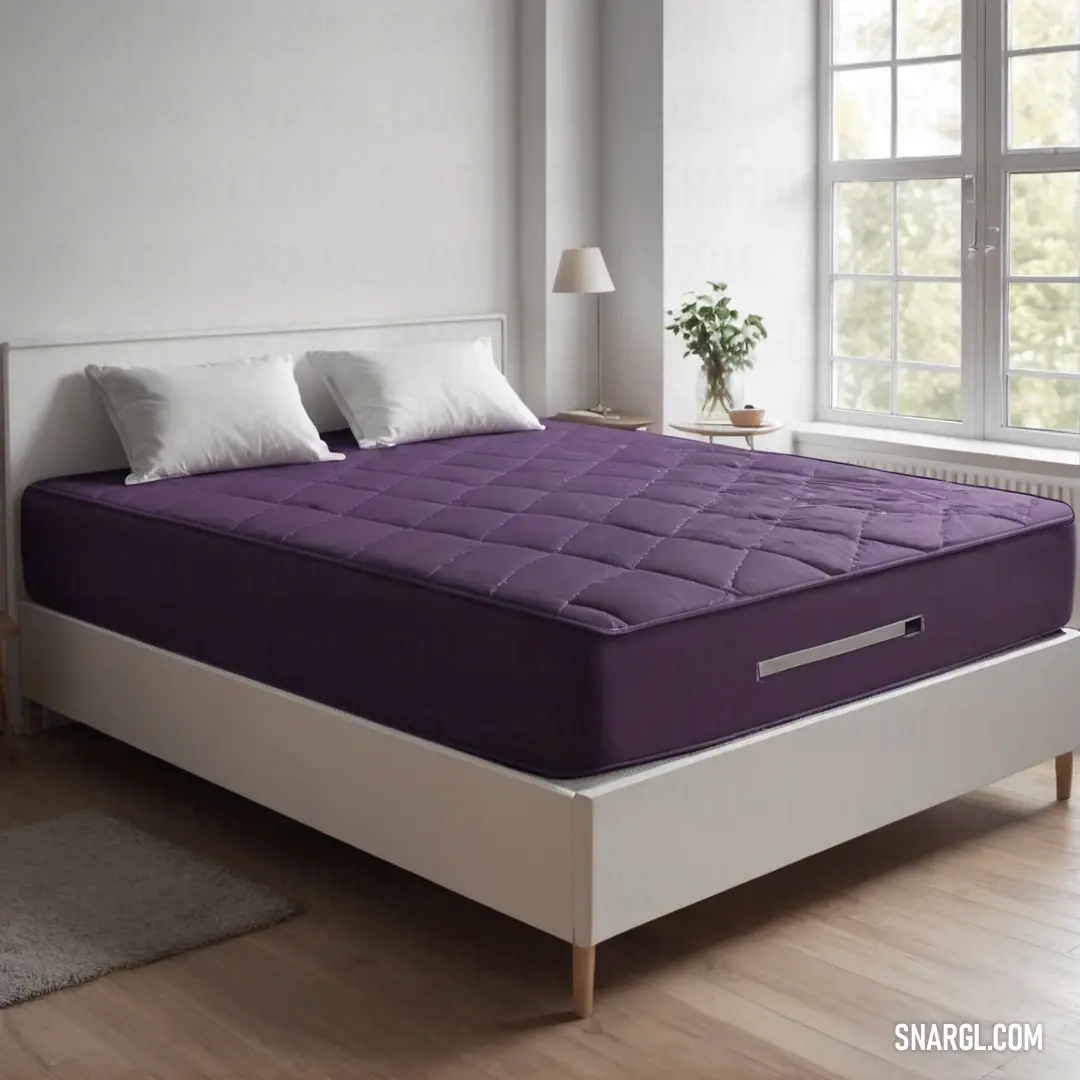 A purple mattress lies on a bed in a room with a window and a rug on the floor beside it. The CMYK 60,70,0,0 color adds a touch of richness and warmth to the cozy, inviting bedroom environment.