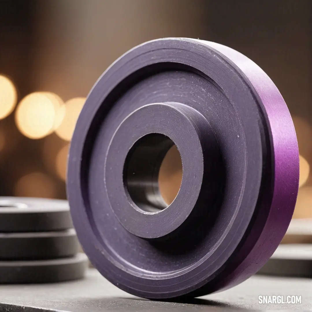 A vibrant purple wheel rests on a table with a soft, blurred background enhancing its dynamic presence. The image captures the beauty of color and form, inviting examination of the wheel's intricate details and the story it may tell.