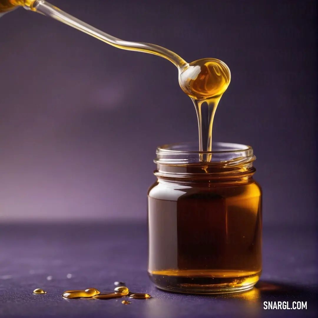 A spoon gracefully pours golden honey into a glass jar set against a vibrant purple background, creating a harmonious blend of colors and textures that evokes feelings of warmth and sweetness.