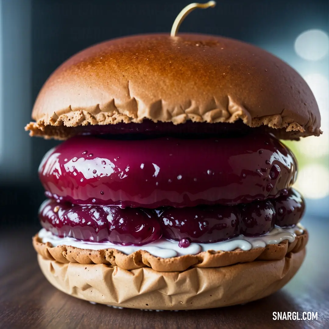 Hamburger with a bun and jelly on it on a table with a blurry background of lights