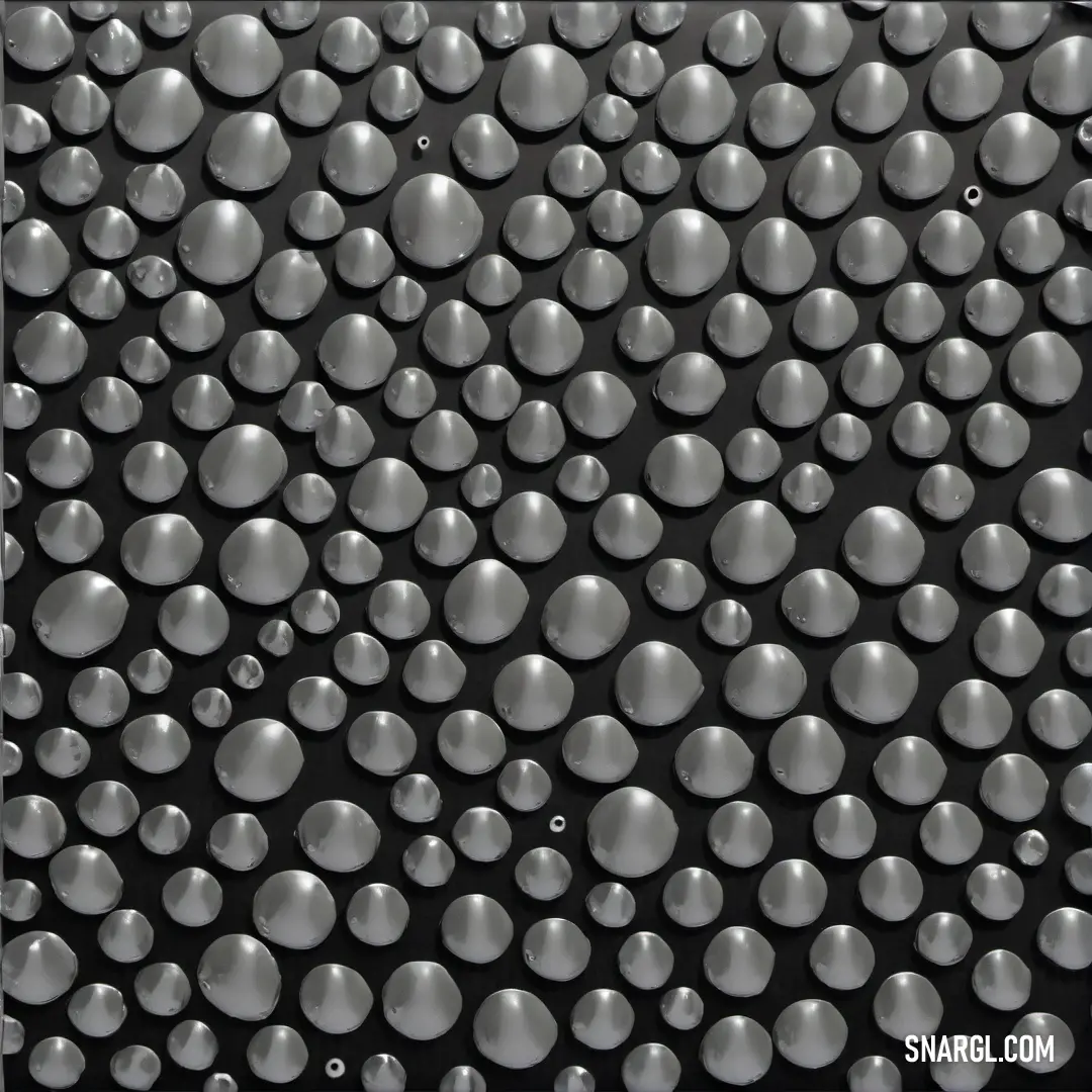 An artistic black and white photograph capturing a collection of bubbles delicately resting on the surface of still water. The dark backdrop enhances the luminous quality of the bubbles, resembling tiny orbs floating in space.