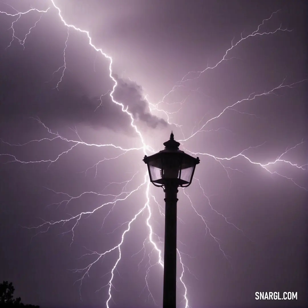 A dramatic scene showcasing a tall street light illuminated against a backdrop of swirling clouds illuminated by fierce lightning strikes, creating an electrifying atmosphere and showcasing the CMYK color model with vibrant shades of blue and grey.