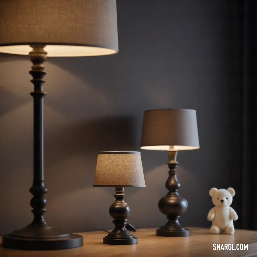 An adorable teddy bear nestled beside a stylish lamp on a table adorned with a chic lamp shade. The comforting scene is enhanced by the warm tones of PANTONE 2177.