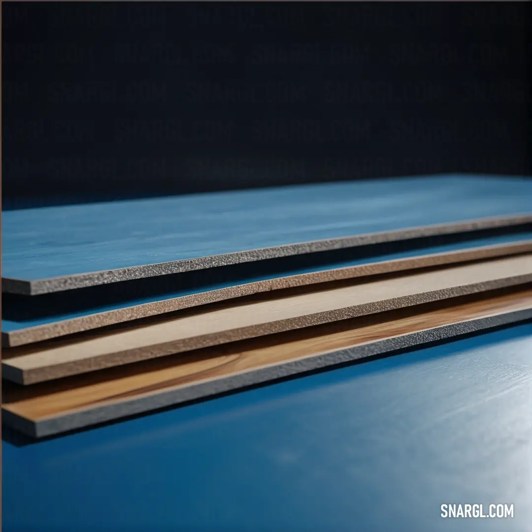 A close-up view of three distinct wood planks lying elegantly on a dark table, revealing their unique textures and hues against a contrasting black background that enhances their natural beauty.