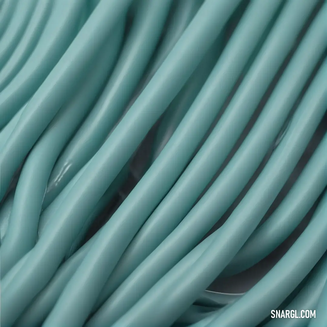 A close-up reveals a striking blue cable intertwined with a sleek black cord, both elegantly poised against a contrasting background. This snapshot of color juxtaposition represents sophistication and modernity, exemplifying the color #5889A1.