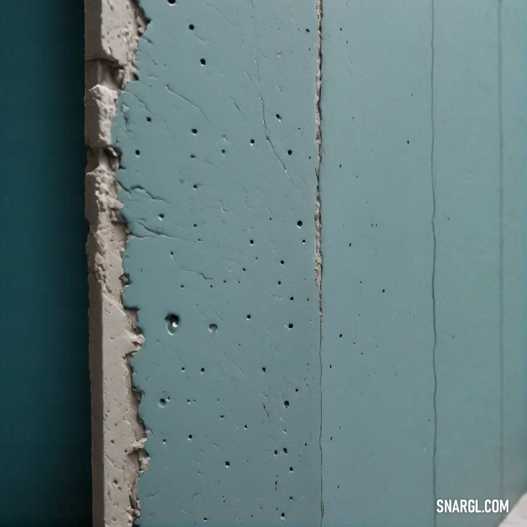 A close-up shot of a wall where blue paint is chipping off, exposing textures and layers beneath. The image exemplifies the PANTONE 2211 color, adding a raw and organic feel to the peeling paint.