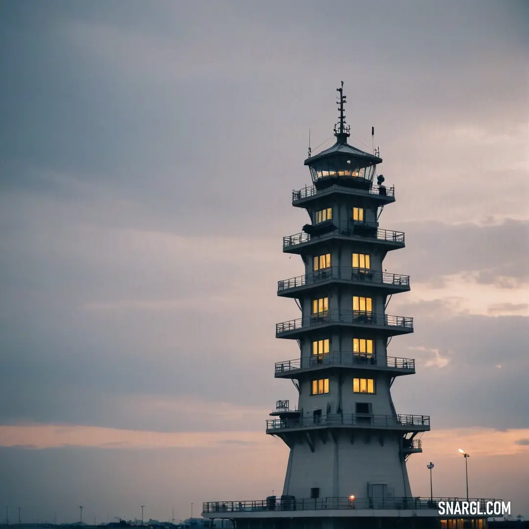 A stunning tower crowned with a striking clock against a backdrop of dusky clouds, the silhouette defined in rich shades of PANTONE 2211. This capture evokes a sense of time passing, as the scene shifts from day to night, inviting reflection.