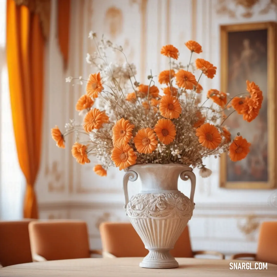Vase with flowers in it on a table in a room with chairs and a painting on the wall. Color #BC9C7D.