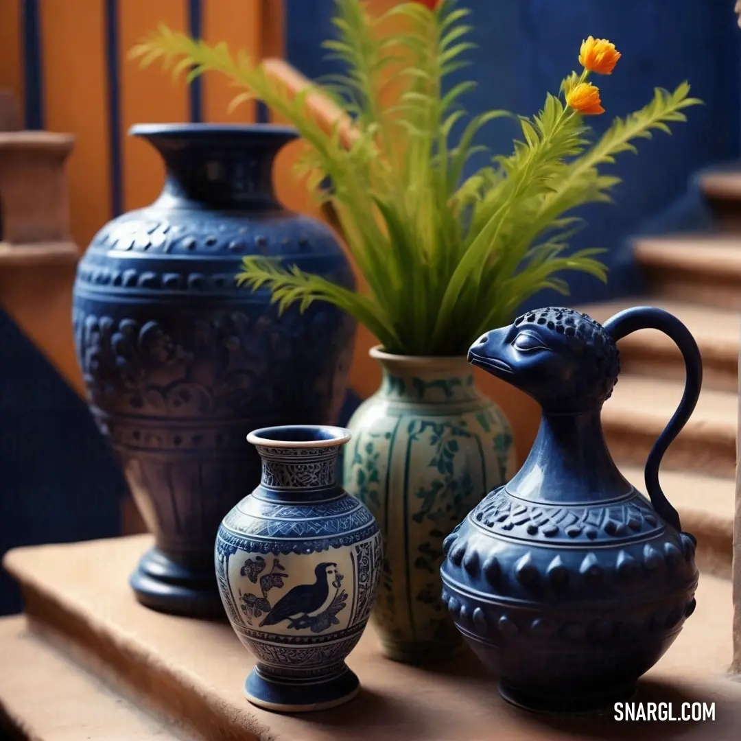 Group of vases on a wooden table next to a plant and a vase with flowers in it. Example of #53599C color.