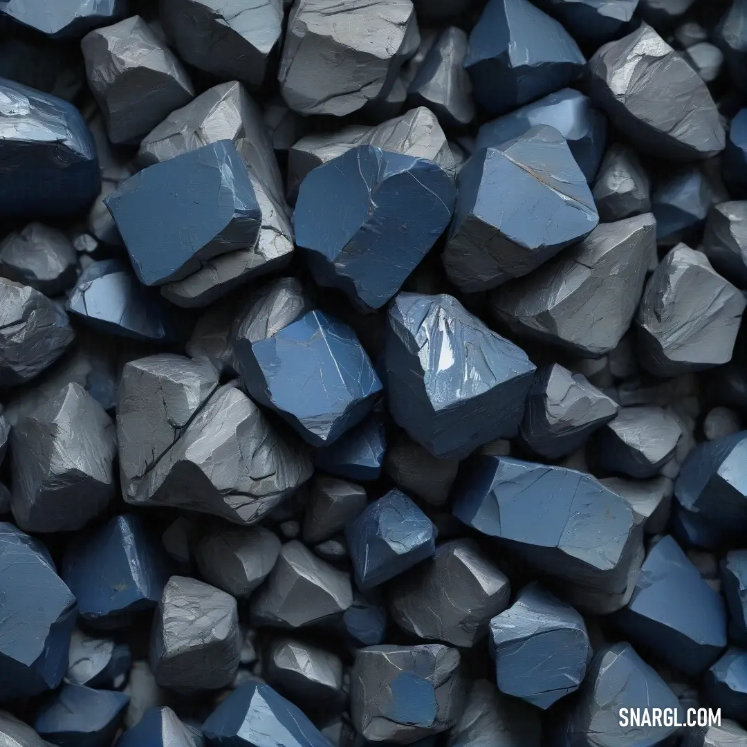 A pile of rocks in shades of blue and gray, textured with rugged surfaces. The natural color palette blends harmoniously, with a black background providing depth to the scene. A true representation of PANTONE 2369.