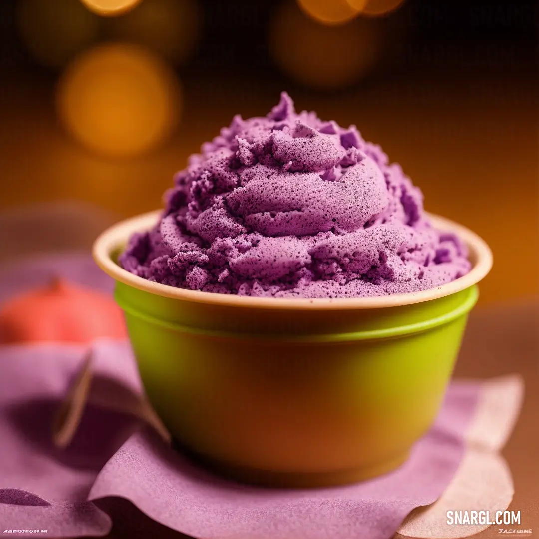 Bowl of purple ice cream on a table with a spoon in it